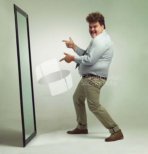 Image of Mirror, portrait and man with smile pointing, double chin and happiness for reflection in studio. Overweight, plus size and male person with obesity, comic and excited to change unhealthy life