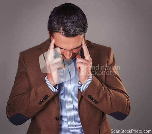 Image of Business man, headache and stress in studio, burnout and fear or temple massage for pain. Male person, migraine and gray background for mental health, frustration and overwhelmed by pressure