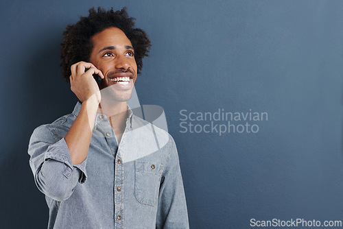 Image of Man, phone call and communication in studio for talking connection on blue background for chat, networking or smile. Male person, cellphone and mockup space for connectivity, contact us or discussion