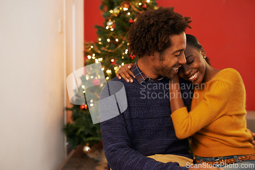 Image of Couple, embrace and Christmas holiday at tree in apartment living room for festive season celebration, vacation or decoration. Man, woman and hug bonding for relaxing connection, present or break