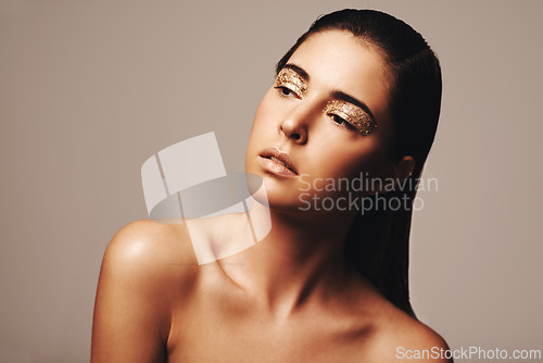 Image of Woman, makeup and gold eyeshadow for beauty, cosmetology and glamour with cosmetics on beige background. Glitter on eyes, elegance and fashion model in studio, art or creativity with shimmer and glow