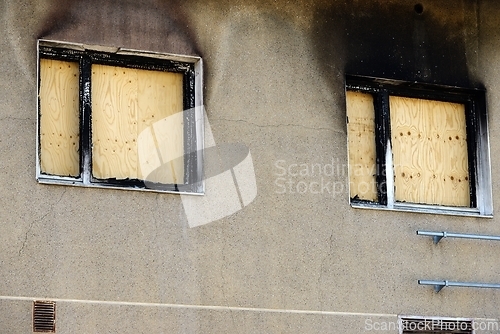 Image of windows boarded up with plywood after a fire