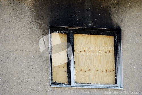 Image of window boarded up with plywood after a fire