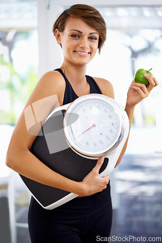 Image of Portrait, scale and happy woman eating apple for diet, nutrition or wellness with healthy body after exercise. Weight loss, smile and person with green fruit, vitamin c or organic food for fitness