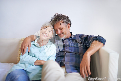 Image of Old couple, hug and relax on sofa with happiness at home, love and security with comfort for bonding. Marriage, partner and retirement together with smile, trust and loyalty with people in lounge