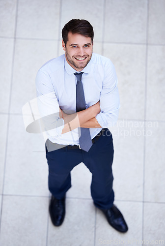 Image of Business, portrait and high angle of man with arms crossed in office with confidence and pride. Above, entrepreneur and person in lobby to start morning in corporate London workplace with perspective