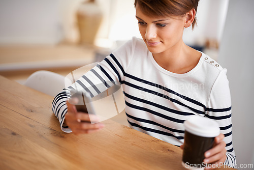 Image of Cellphone, smile and woman with coffee in dining room networking on social media, mobile app or internet. Happy, technology and female person with cappuccino scroll on a phone at modern apartment.