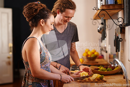 Image of Home, happy couple and cutting orange in kitchen for healthy diet, nutrition or wellness. Man, woman and chopping board with fruit at table for meal prep or food for organic breakfast in rasta house