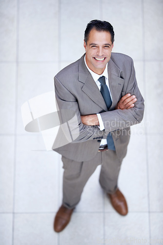 Image of Happy, portrait and high angle of man in business or office with professional confidence and pride. Above, entrepreneur and person smile in lobby excited for morning in London at corporate workplace