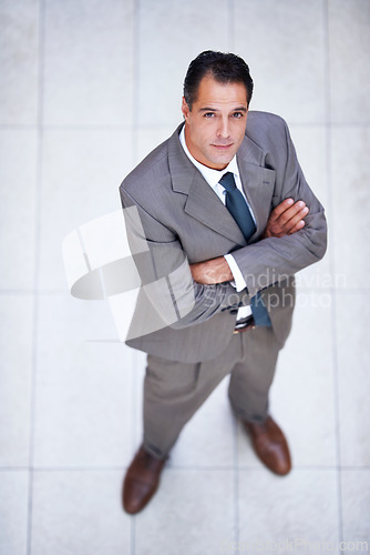 Image of Man, portrait and high angle with arms crossed in business or office with professional confidence and pride. Above, entrepreneur and person in lobby to start morning in London at corporate workplace