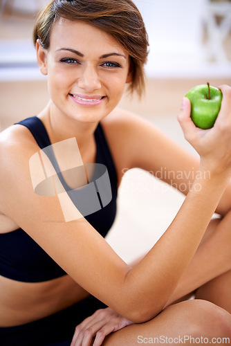 Image of Portrait, exercise and happy woman with apple in gym for diet, nutrition and wellness with healthy body. Face, fitness and smile of person eating fruit for vitamin c and benefits of organic food