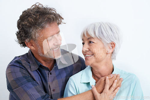 Image of Old couple, smile with happiness and love in studio, hug and security with comfort for bonding. Marriage partner, retirement and connection with people for trust and loyalty on white background