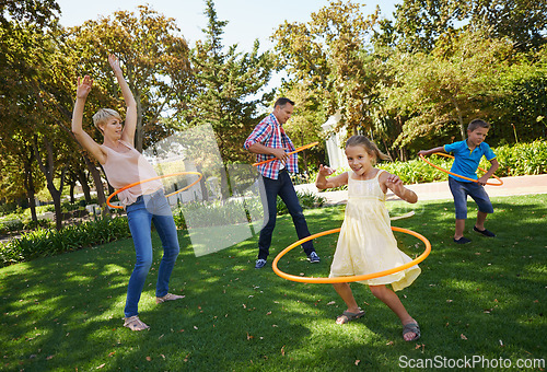 Image of Parents, kids and hula hoop in park for playing, child development and motor skills outdoor. Children, son and daughter with mom and dad in nature for leisure, family time and bonding with smile