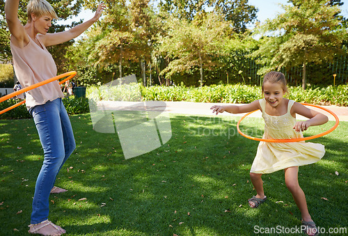 Image of Mother, child and hula hoop for outdoor fun in backyard garden for parenting bonding, summer or holiday vacation. Woman, daughter and recreation connection on grass for playing, carefree or happy