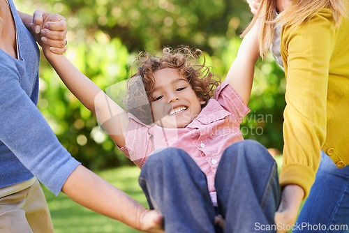 Image of Kid, women or swing to play as family, lgbt or lesbian parents as diverse, inclusive or adoption. Couple, boy or holding hands to support, trust or care as bonding together in park on spring morning