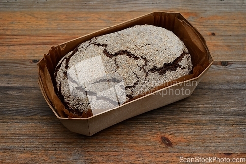 Image of loaf of fresh rye bread in a wooden box 