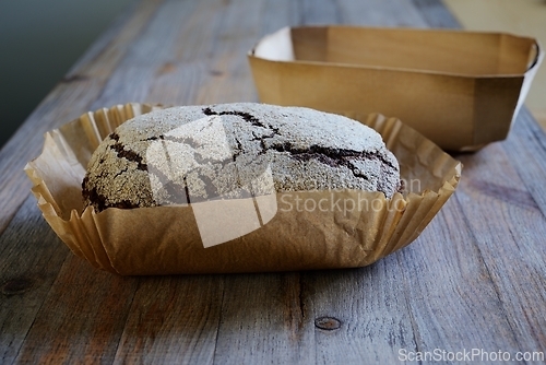 Image of loaf of fresh rye bread in baking paper