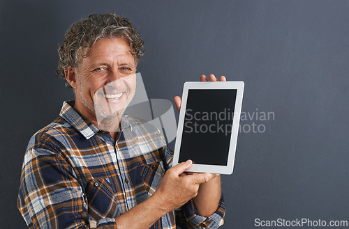 Image of Tablet, screen and portrait of mature man in studio and learning about technology on dark background. Advertising, tech and mockup with post online to social media and person search internet for news