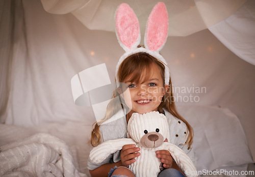 Image of Girl, child and bunny ears with teddy bear, soft toys and playing in fort for camping and fun at family home. Happiness, innocent and kid with stuffed animal, games for Easter and joy in childhood