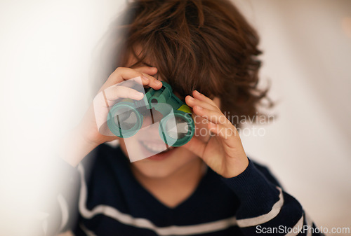 Image of Boy, child and binocular with toys and playing, youth for fun and innocent with search or surveillance. Investigate, looking or curiosity with discovery on adventure, playful with games and activity