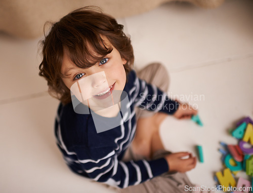 Image of Boy, child and smile with letter toys to learn, development and games in playroom at home. Portrait, education and growth in childhood with alphabet, language and kid playing for fun with top view