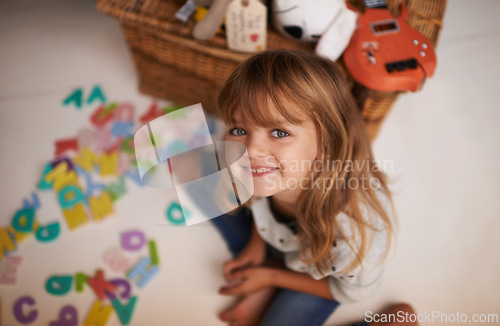 Image of Girl, child and smile with letter toys for learning, development and games in playroom at home. Portrait, education and growth in childhood with alphabet, language and happy kid playing for fun