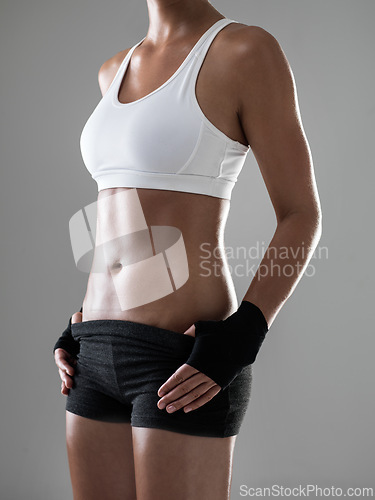 Image of Woman, six pack with body and kickboxing for fitness, strong with muscle and sweat from workout on grey background. Boxing, self defense training and athlete for sports, exercise and power in studio