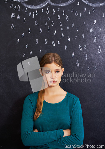 Image of Rain, sad and woman with cloud on chalkboard for depression, unhappy and upset mood. Storm, winter weather and person with crossed arms for attitude, emotion and worry expression on dark background