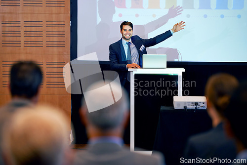Image of Business man, podium and presentation, pointing at projector screen at conference or workshop with laptop for PPT. Corporate training, seminar and speaker with info, audience and professional speech