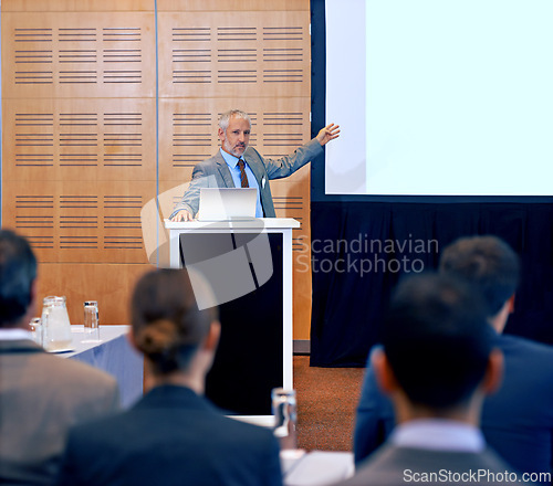 Image of Senior, businessman and speaker with presentation on projector for meeting, seminar or conference at office. Man, CEO or spokesperson talking on podium to group or corporate audience at workshop