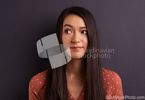 Image of Thinking, woman and ideas with doubt, decision and confused on a grey studio background. Person, mockup space and girl with a choice or questions with why and thought with solution or problem solving