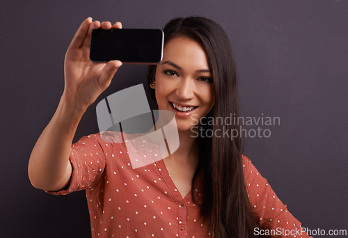 Image of Woman, selfie and social media for online connection on studio for profile picture, technology or grey background. Female person, smiling and internet communication for update post, vlog or mockup