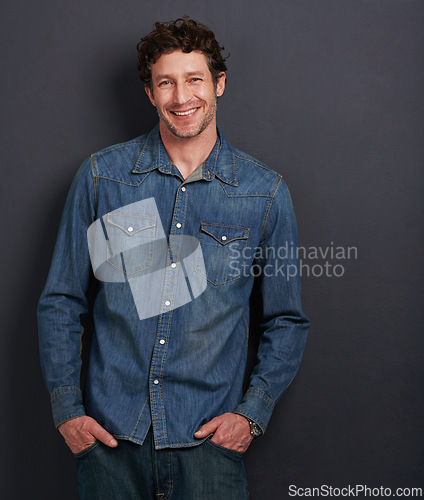 Image of Portrait, fashion and man with a smile, confidence and stylish clothes on a grey studio background. Face, person and model with casual outfit or cheerful model with pride and joyful with mockup space