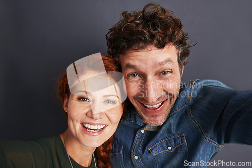 Image of Love, selfie and happy couple in studio together with relationship trust, care and support. Photography, man and woman smile on dark background with commitment, loyalty and affection in marriage