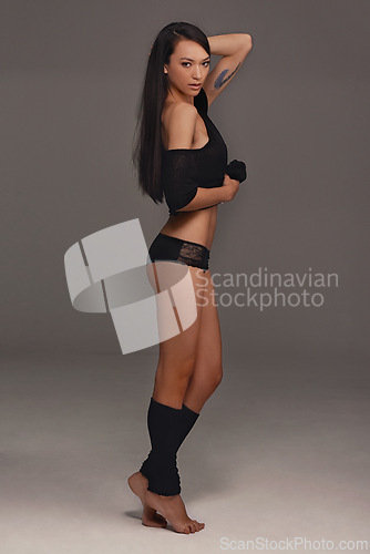 Image of Portrait, woman and lingerie with fashion, confidence and pose on a grey studio background. Full body, person and model with underwear and wellness with mockup space and aesthetic with clothes