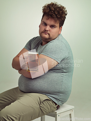 Image of Portrait, arms crossed and plus size man with alcohol for unhealthy habit, serious and weight gain in studio of white background. Face, beer and male person by drink for stomach, calories and carbs