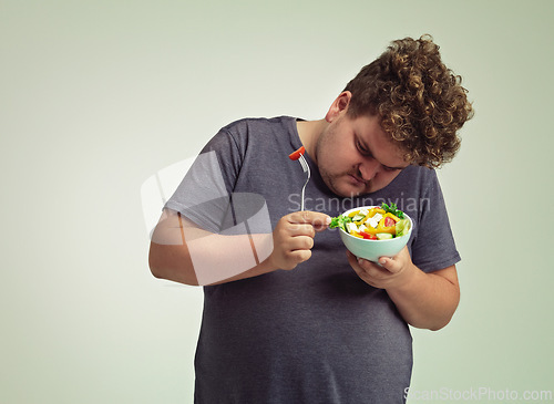 Image of Bowl, man and thinking with salad in studio for healthy diet, weight loss and examine food. Plus size, male person and contemplating with organic meal for detox, lifestyle change and nutrition