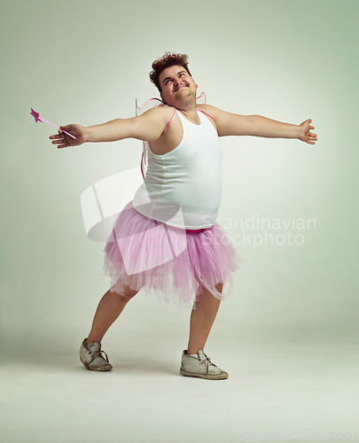 Image of Fairy, man and studio for magic and isolated, happy male person with wings and pretend costume. Pink Cosplay, fun and plus size model, dress up or play on white background for halloween on backdrop