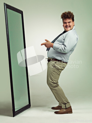 Image of Mirror, portrait and man with happiness for pointing, excited and smile for reflection in studio. Adult, plus size and male person with comic, guy and positive to change unhealthy diet and life