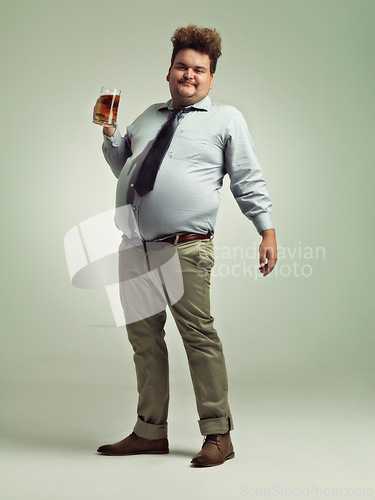 Image of Plus size, portrait and man with beer in studio to enjoy drinking alcohol from pint glass for fun. Adult, guy and male person with smile, drunk and holding mug with beverage in party for break