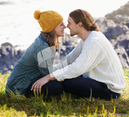 Image of Happy, couple and together in nature or sitting on grass, hilltop and scenery or people looking with love. Care, smile and romantic date on winter vacation, holiday and relationship in Sweden