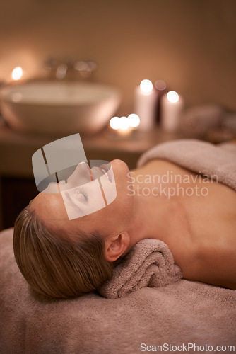 Image of Blonde woman, massage therapy and candlelight for wellness, smile and relaxation to destress and pamper. Female person, self care and cleanse for detox, spa day and peace for beauty and happiness