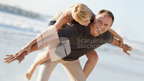 Image of Couple, love and smile on beach with piggyback for bonding, honeymoon date and weekend holiday. Face, man and woman with embrace, happy and care in California by sea for vacation, travel or adventure