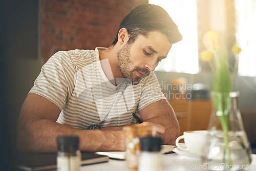 Image of Man, coffee shop and freelancer for writing notes, inspiration and writer for creativity in restaurant. Male person, journal and plan for story or author, calm and peace in cafe for script project