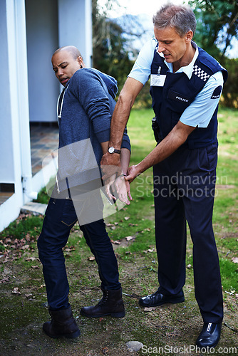 Image of Police officer, handcuffs and outdoor to arrest man for crime with safety, protection or security. People, law enforcement and government service for justice, peace or authority for danger in society