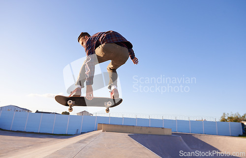 Image of Sports, fitness and man with skateboard, jump or ramp action at a skate park for stunt training. Freedom, adrenaline and gen z male skater with energy, air or skill practice, exercise or performance