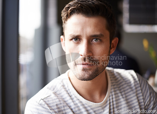 Image of Handsome man, portrait and serious face at cafe for morning, ambition or aspiration at indoor restaurant. Attractive or young male person with beard in relax, casual clothing or style at coffee shop