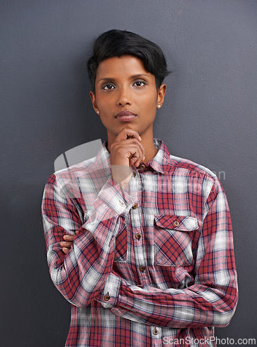 Image of Portrait, serious and Indian person with designer and gray background at a creative agency office. Hipster, confidence and non binary employee with modern and casual clothing with fashion and style