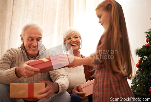 Image of Family, christmas giving and gifts with kids and grandparents together with tree in living room. Home, happy and present with holiday and celebration at a party with love, care and bonding with smile