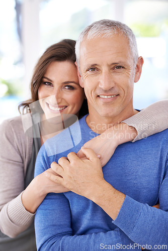 Image of Couple, portrait and happy in home for hug with support, trust and romance in living room of house. Senior man, woman and smile with face for embrace, affection and healthy relationship in apartment